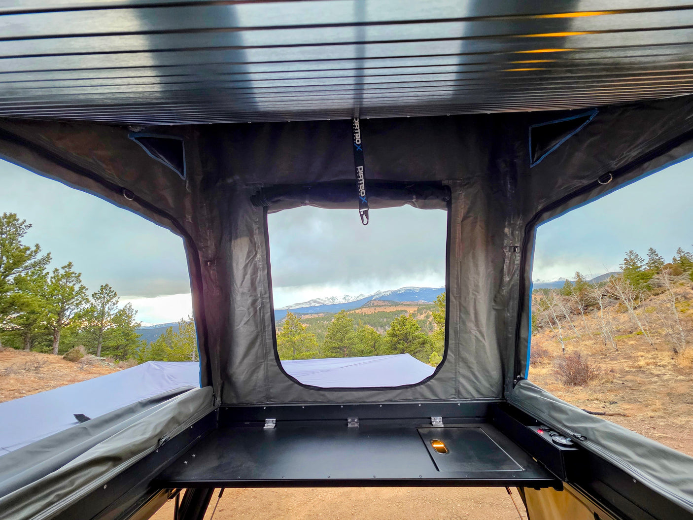 Scenic mountain view from inside an RV rental rooftop tent, featuring a built-in counter for your outdoor camping adventure.