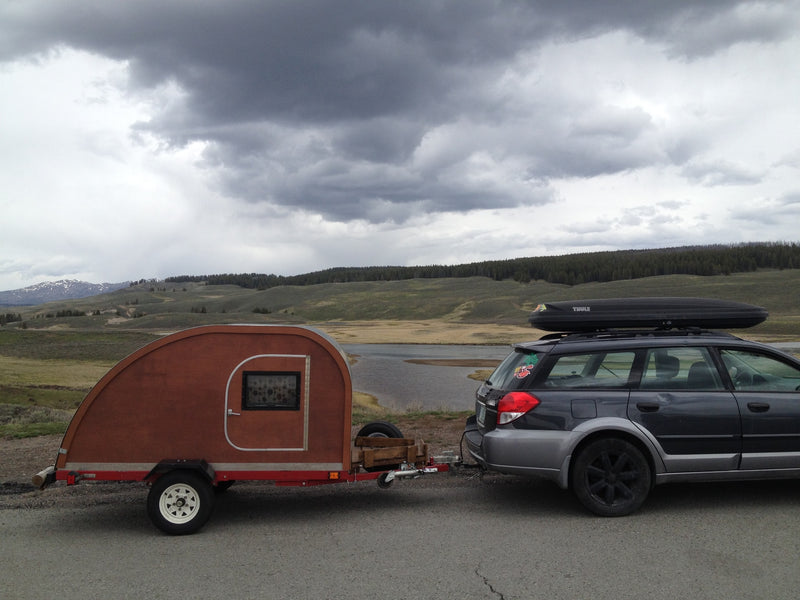  framed by pines and snow-capped mountains. Perfect for camping adventures!|Dark grey Subaru wagon towing a teardrop RV rental — photo 2