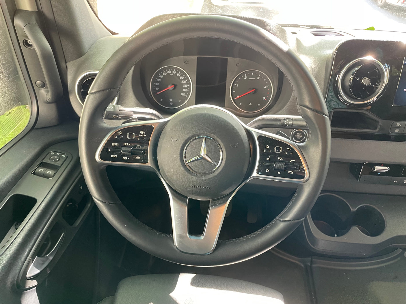 Inside a modern **RV rental**, featuring a Mercedes-Benz steering wheel, dashboard, instrument cluster, and driver's controls.