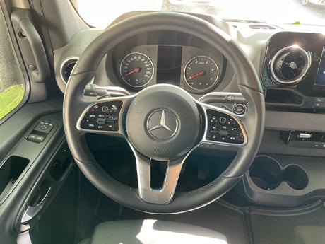 Inside a modern **RV rental**, featuring a Mercedes-Benz steering wheel, dashboard, instrument cluster, and driver's controls.