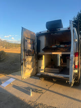 Explore the outdoors with this cozy RV rental! Inside, a comfy bed, dog bed, and organized storage await your next adventure.