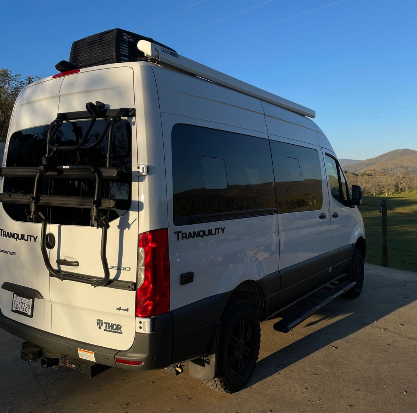  hilly backdrop.|White RV rental camper van parked with open doors — photo 5