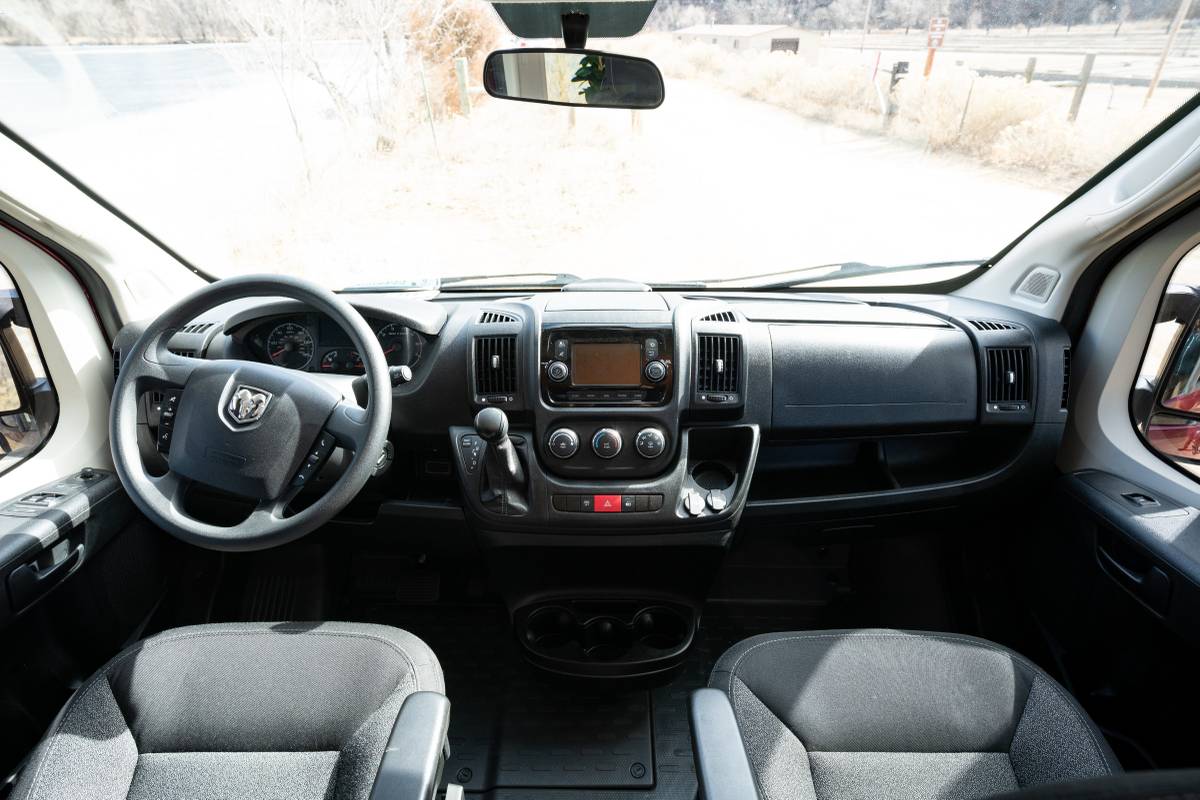  parked on a dirt road beside a lake. Ready for adventure.|Inside a comfortable RV rental: dashboard view with steering wheel — photo 4