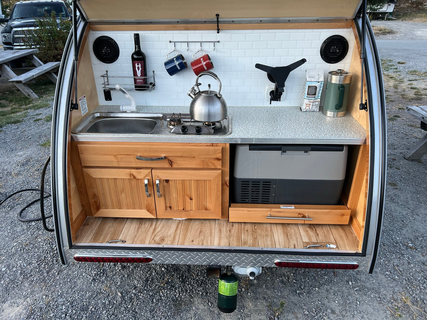  is parked at a campsite with its rear galley open.|Explore the outdoors with this teardrop RV rental — photo 4