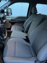 Comfortable grey fabric seating and steering wheel inside a clean RV rental, ready for your next trip.