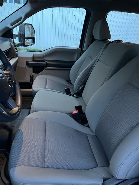 Comfortable grey fabric seating and steering wheel inside a clean RV rental, ready for your next trip.