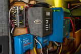 Detailed view of an **rv rental's** power hub: Victron MultiPlus, Orion DC-DC, MPPT, and fuse panel for reliable off-grid travel.