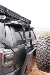 RV rental-ready SUV with Roofnest tent, ladder, & spare tire. Perfect for dusty off-road camping adventures.