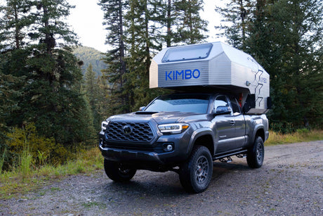 This dark gray Toyota Tacoma with a Kimbo truck camper is ideal for your next RV rental & overland camping trip.