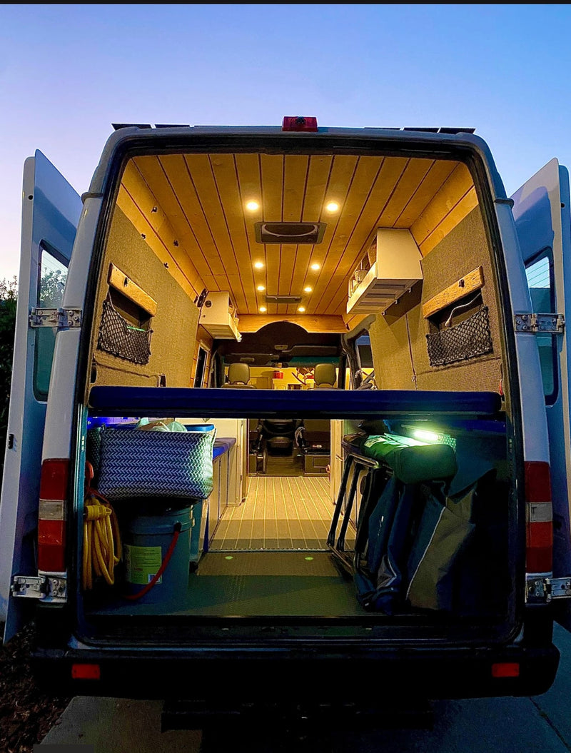 Spacious custom RV rental interior, seen from the rear. Features wood ceiling, kitchen, and ample storage. — photo 8