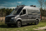 Dark grey Mercedes-Benz Sprinter camper van, an ideal rv rental, parked on grass. Off-road ready.