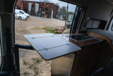 RV rental comfort: A clever Lagun table and compact kitchen setup in a custom camper van, perfect for mobile living.
