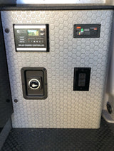 An RV rental's electrical panel: Zamp solar controller (FUL), Freedom HFS remote, battery switch, and AC outlets for power management.