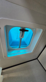 Inside an RV rental: a bright blue ceiling vent/skylight with a control handle and screen visible.