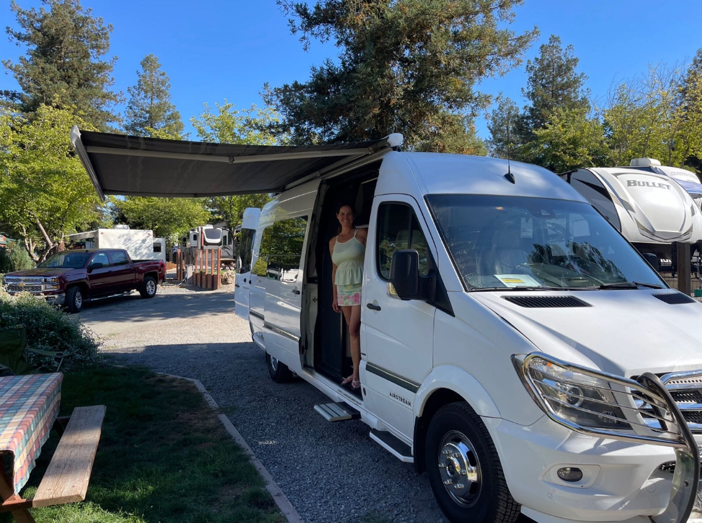  with other RVs nearby.|RV rental's luxurious beige interior with a comfortable rear bench and two individual front seats — photo 2