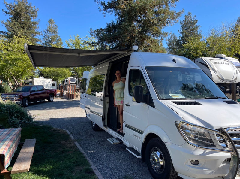  with other RVs nearby.|RV rental's luxurious beige interior with a comfortable rear bench and two individual front seats — photo 2