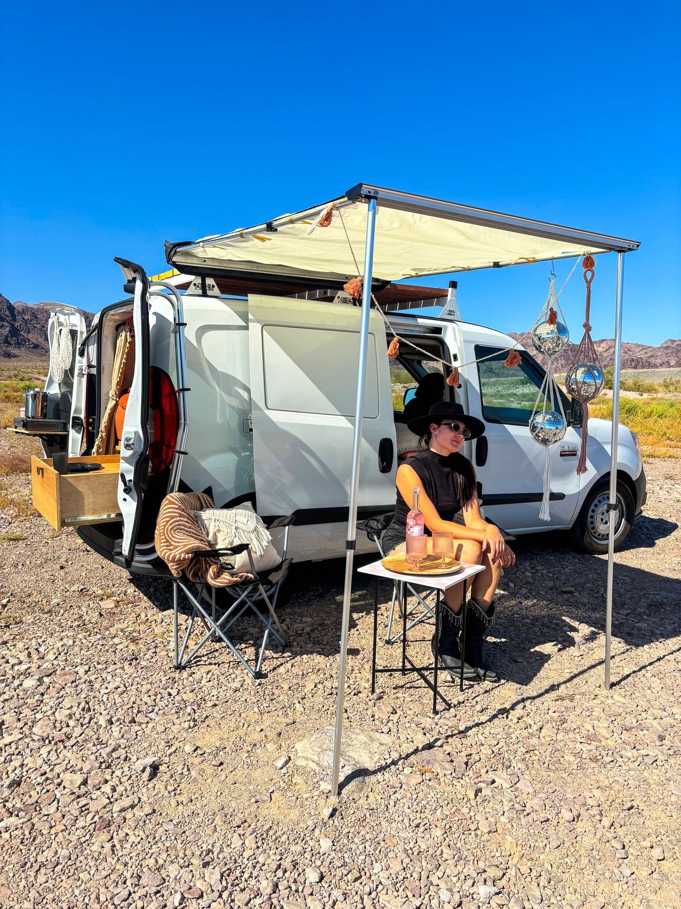 and smart under-bed storage for van life adventures.|View inside a stylish RV rental van conversion: comfy orange bed — photo 9