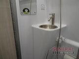 This RV rental's compact bathroom features a stainless steel sink, modern faucet, mirror, and shower, perfect for travel.