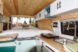 Inside this cozy rv rental, a full bed offers rear views. The kitchen features a sink & stovetop. Perfect for van life adventures!