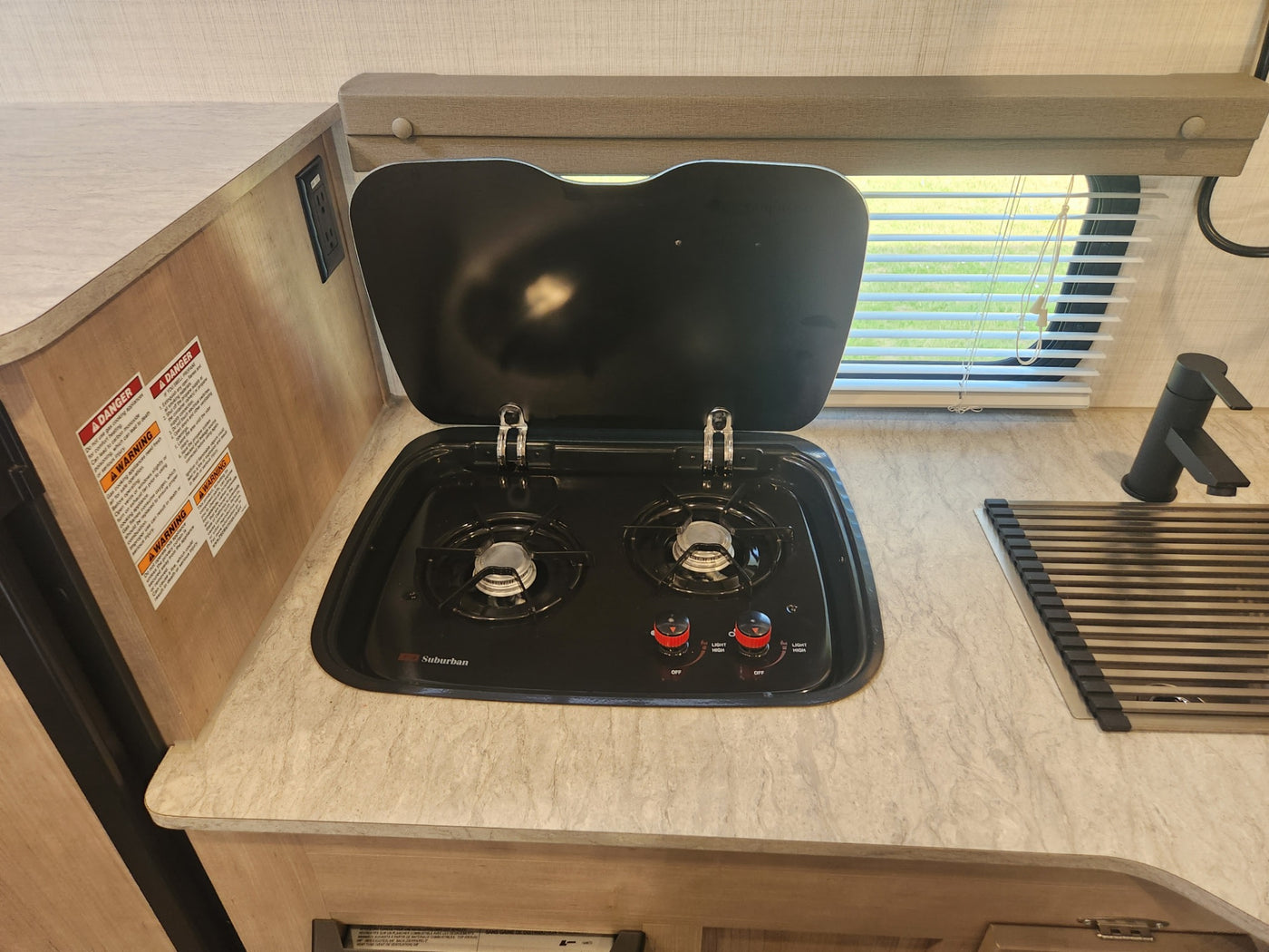  and sunlit window blinds.|Compact interior of an rv rental features a kitchen — photo 10