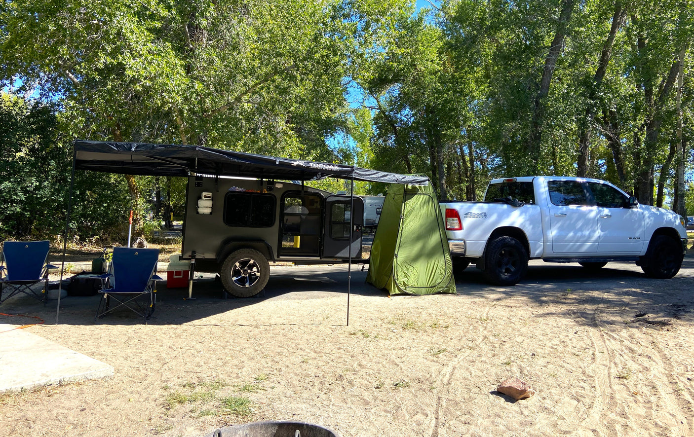 This RV rental features a rugged camper & truck, perfect for outdoor adventures with an awning & privacy tent.