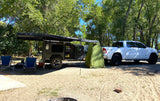 This RV rental features a rugged camper & truck, perfect for outdoor adventures with an awning & privacy tent.