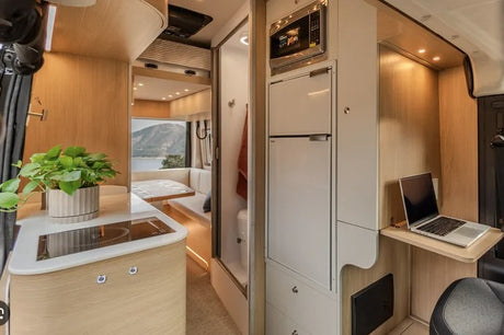 Modern RV rental interior with kitchen, dining, laptop desk, and stunning mountain views. Ideal for road trips.