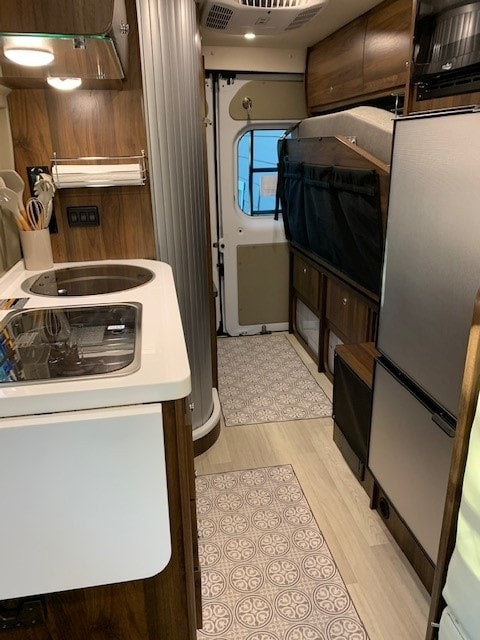 Experience RV rental comfort: detailed view of a compact kitchen, folded bed, and clever storage solutions. — photo 6