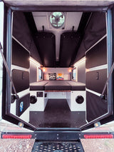 Inside this RV rental, discover a well-designed camper interior with a comfortable bed, convenient storage, and ventilation.