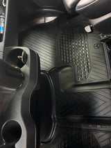 RV rental interior: black rubber floor mats with Mercedes-Benz logo, showing a clean passenger footwell and cup holder.