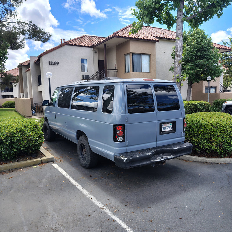 Light blue van, a potential RV rental, parked at apartment building 11169 under a cloudy blue sky. — photo 7