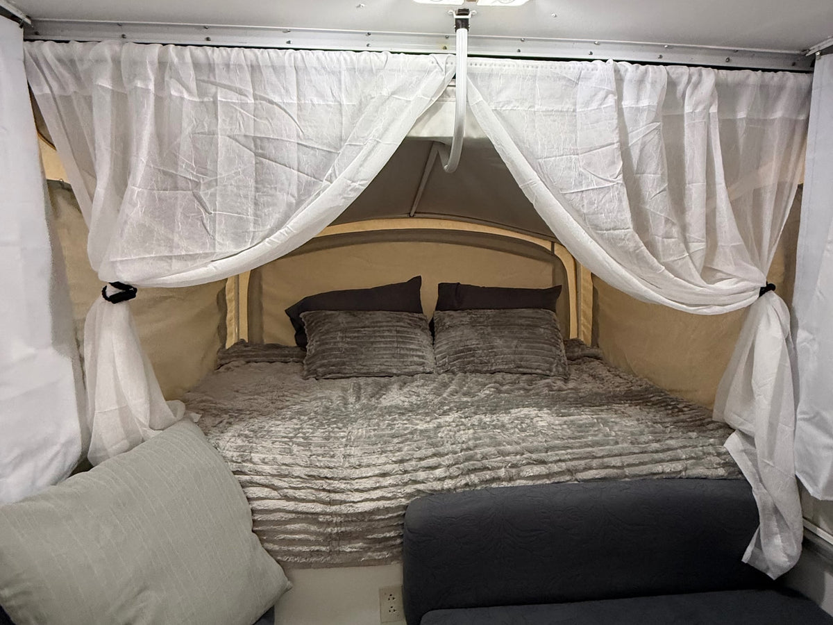  & crisp white curtains.|Cozy rv rental camper interior featuring a dinette with a table — photo 9