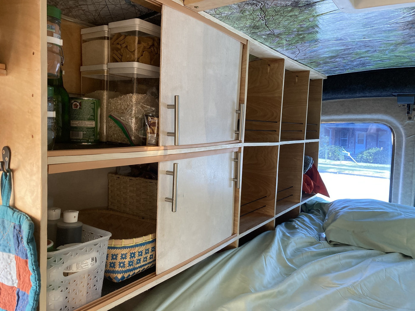 Custom RV rental interior with organized storage shelves, sliding doors, and a cozy bed for travel adventures. — photo 10