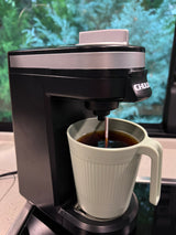 A CHULUX coffee maker brews fresh coffee into a green mug, perfect for your RV rental morning adventure.