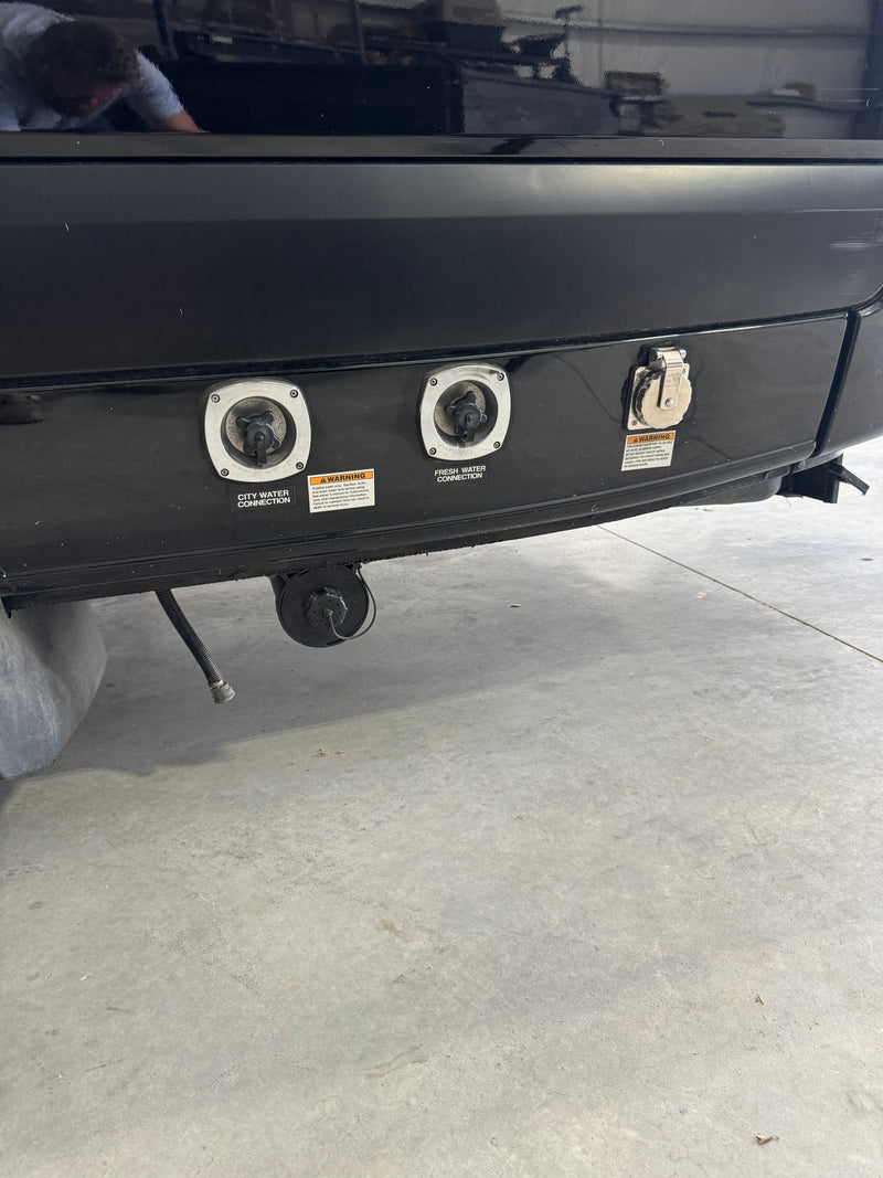 RV rental's rear panel: city water, fresh water, and 30-amp power connections for essential hookups at a campsite. — photo 5