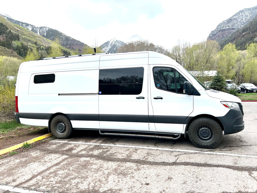 White Sprinter RV rental van in a mountain setting, ideal for adventure & road trips.