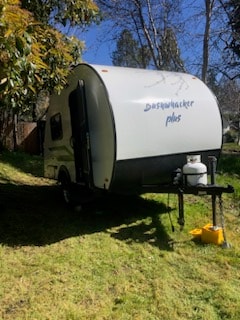  ready for adventure.|A compact white Bushwhacker Plus travel trailer — photo 4