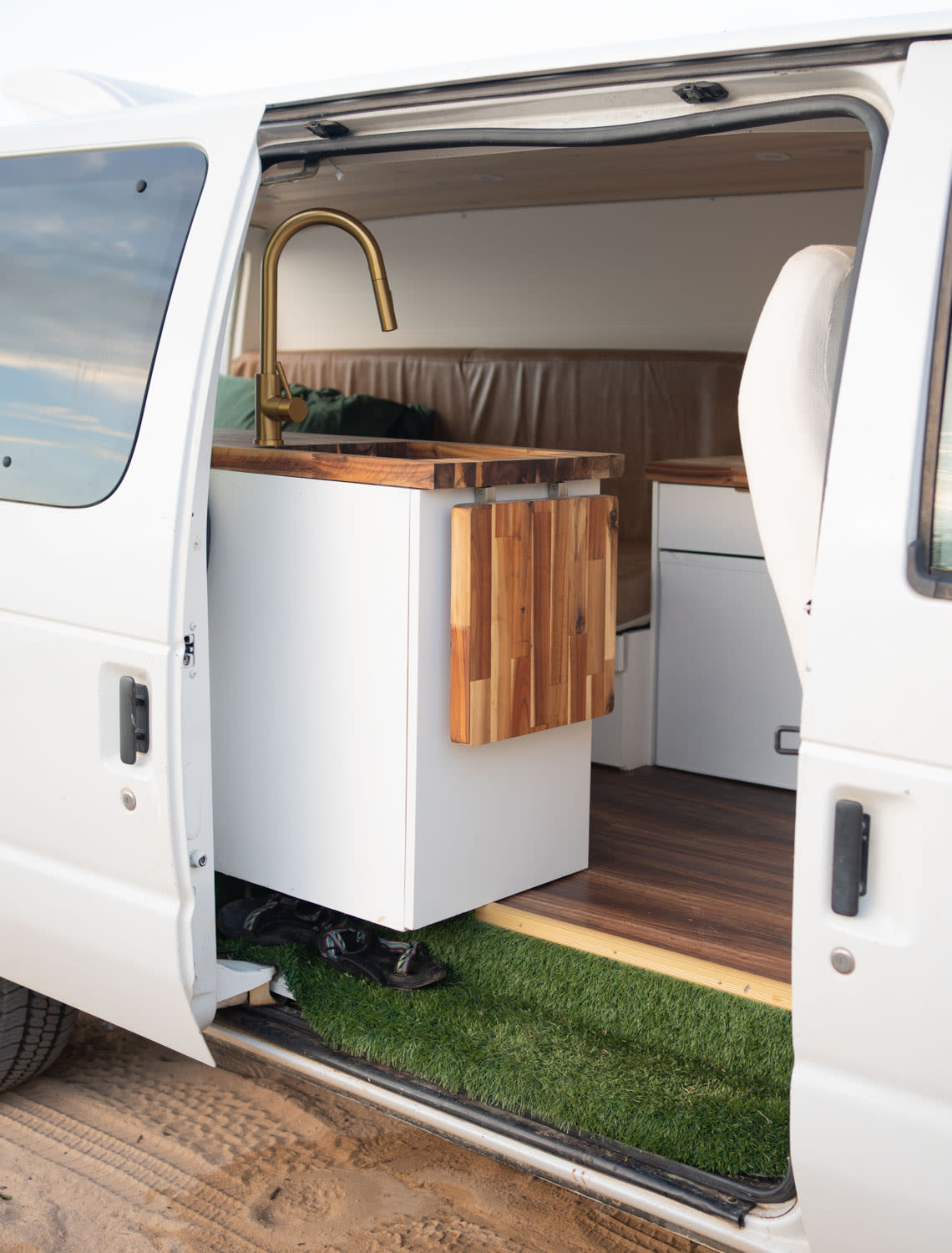  and a round mirror.|This RV rental features outdoor cooking: a mint green portable camp stove on a clever fold-down wooden shelf.|Inside an RV rental: Green velvet steering wheel — photo 17