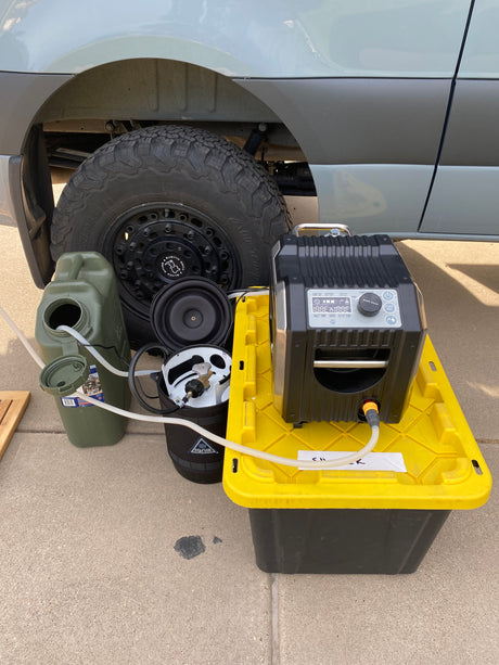 Essential RV rental gear: portable hot water shower system, water tank, and propane for off-grid comfort.