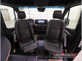 Inside this RV rental: spacious front cockpit with dual black seats, dashboard, and clear views ahead for travel.