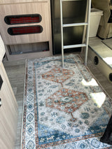 RV rental interior featuring a colorful patterned rug, a bunk ladder, and integrated vents for comfort.