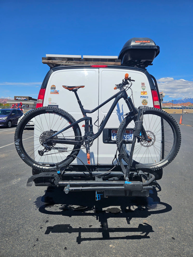  surrounded by rocks.|White RV rental van with a roof cargo box and bike rack — photo 10