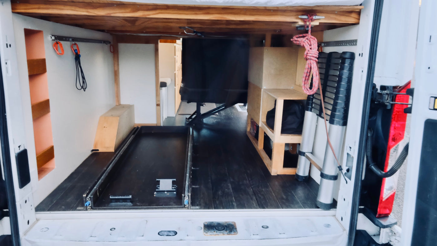  and a kitchenette with a tiled backsplash & wood counters.|RV rental interior: cozy camper van bedroom with patterned duvet — photo 8