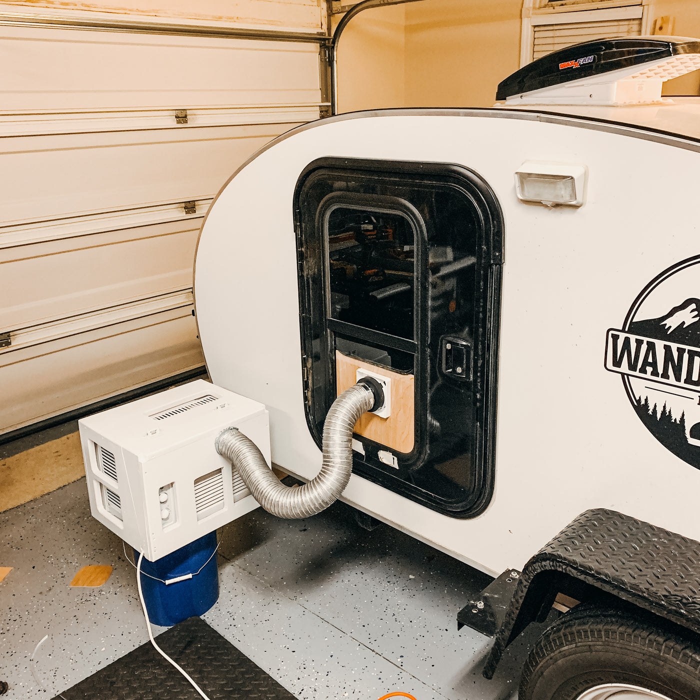 Innovative AC solution for an RV rental: a portable unit ducts cool air into a teardrop trailer in a garage. — photo 11