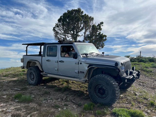 Grey Jeep Gladiator, equipped for rugged trails. Explore beyond traditional RV rentals with this off-road beast!