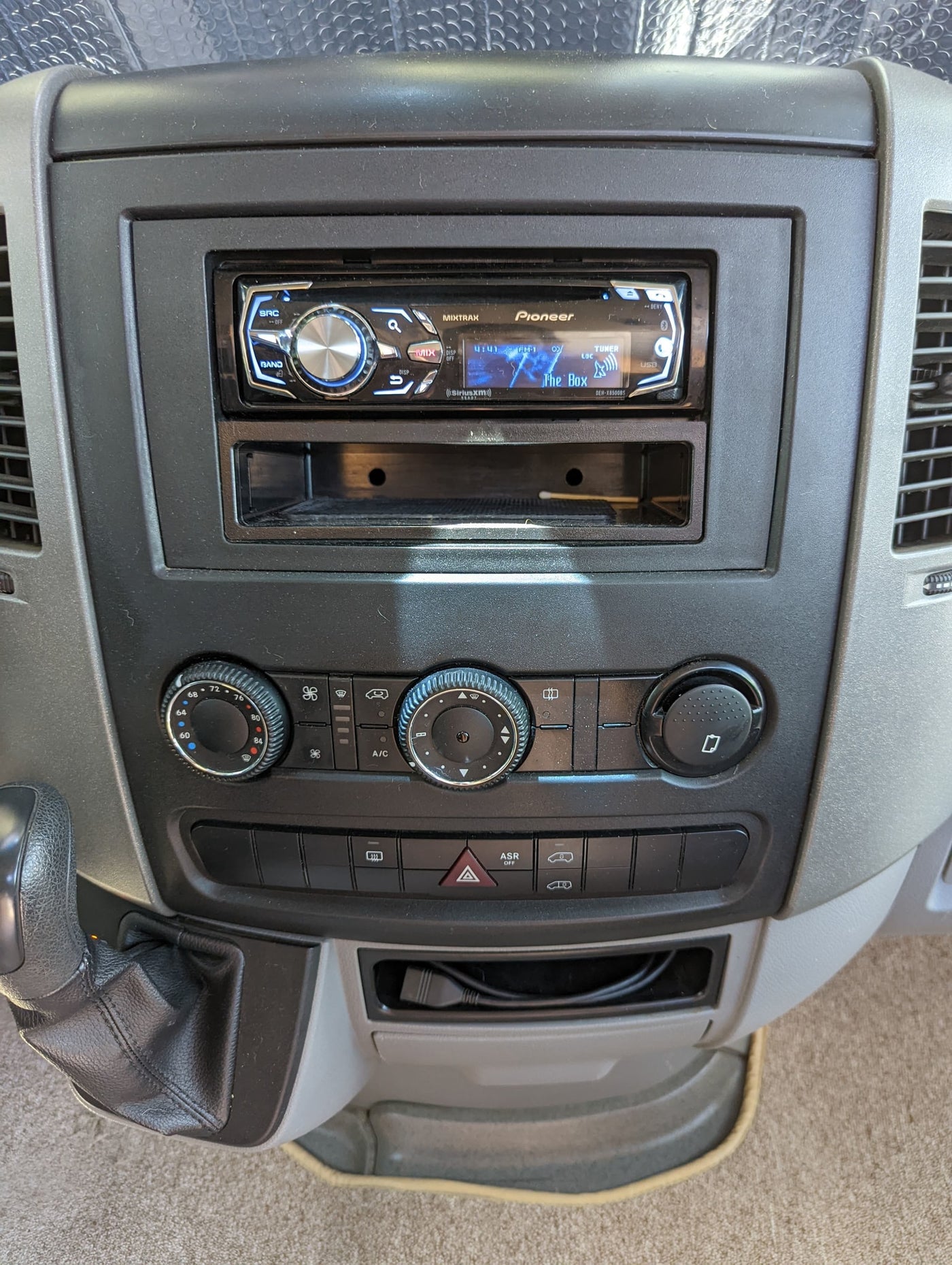 RV rental dashboard: Pioneer stereo playing FM-1, with climate controls, gear shift, and console storage. — photo 13