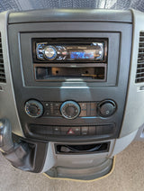 RV rental dashboard: Pioneer stereo playing FM-1, with climate controls, gear shift, and console storage.