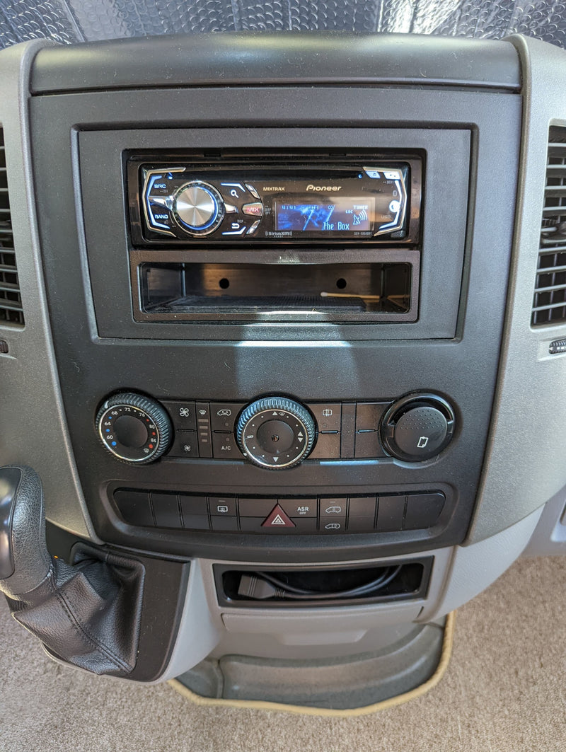 RV rental dashboard: Pioneer stereo playing FM-1, with climate controls, gear shift, and console storage. — photo 13