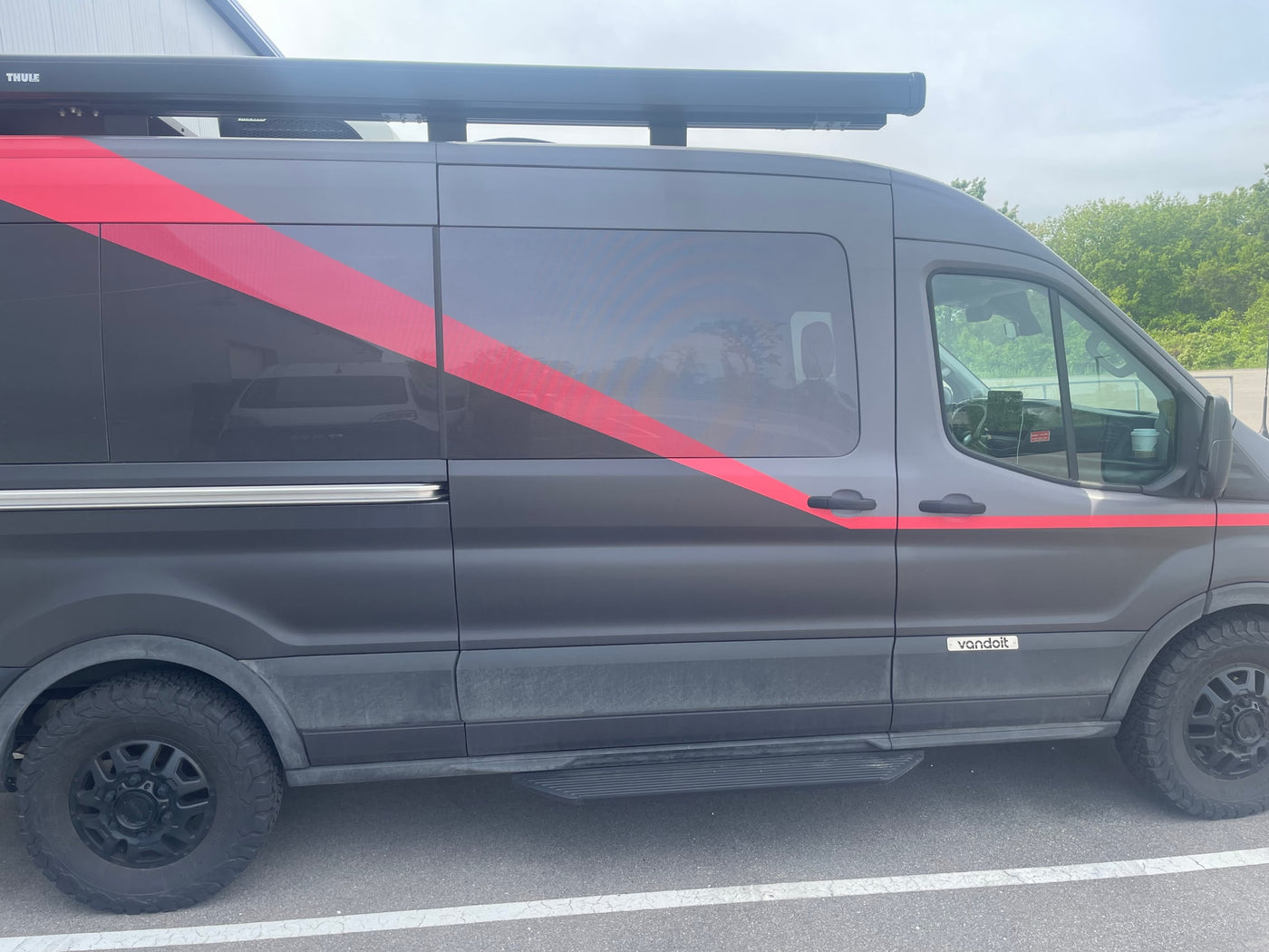  parked. Roof rack equipment visible.|Rear view of a dark Ford Transit camper van — photo 5