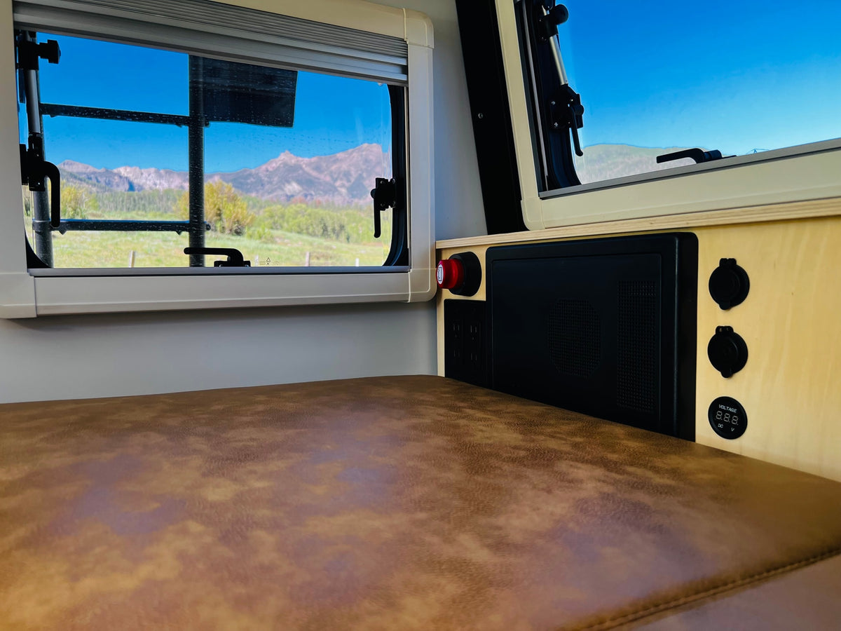 RV rental interior with stunning mountain views, a comfortable seating area, and convenient power outlets. — photo 14